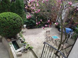 克拉古耶瓦茨Crystal Kragujevac的庭院配有桌椅和粉红色的鲜花。
