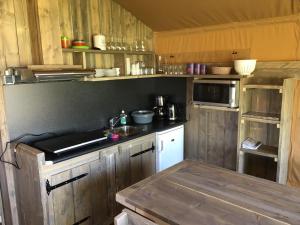 KwadendammeSafaritent 't Kwedammertje的厨房配有木制橱柜和台面