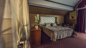 基辅格罗西福公园酒店的酒店客房配有一张床铺和一张桌子。