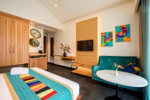 科尔瓦海滩旁贝莱扎酒店的一间卧室配有一张床、一张沙发和一张桌子