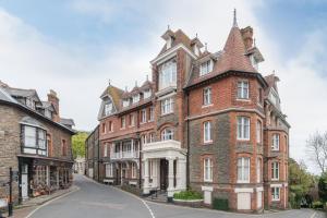 林顿The Valley of Rocks Hotel的街上有一座红砖建筑,有塔楼