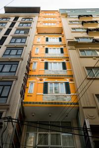胡志明市Ipeace Hotel - Bùi Viện Walking Street的一座高大的橙色建筑,有许多窗户