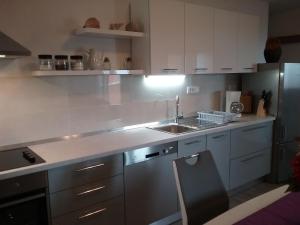 科米扎Apartment Willy的厨房配有白色橱柜和水槽