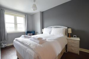 爱丁堡Holyrood Park - Carparking included!的卧室配有白色床和毛巾