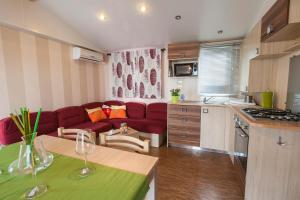 索托马里纳Camping Tredue的厨房以及带红色沙发的起居室。