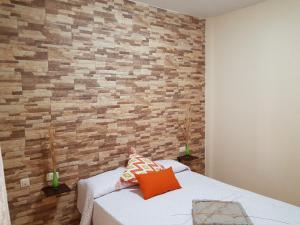 加拉奇科Aptos. Las Salinas的一间卧室设有砖墙和一张床