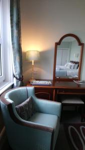 伊斯特布恩威尔明顿广场17号旅馆的客房设有椅子和带镜子的书桌