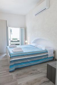 莫诺波利La Dimora sull'Arco的白色卧室配有一张带蓝色毯子的床