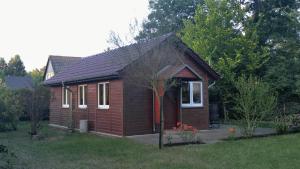 文迪施里茨Ferienhaus Eschenallee的院子里有红色门的小棕色房子