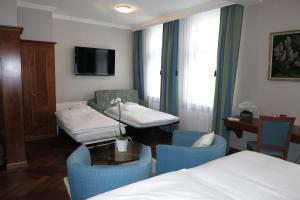 阿彭策尔赫克特阿彭策尔酒店的酒店客房带两张床和一张桌子以及椅子。