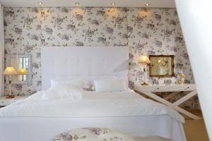 克里斯阿穆迪亚Mare Monte Small Boutique Hotel的卧室配有白色的床和花卉壁纸