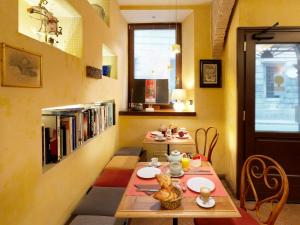 的里雅斯特Boutique Hotel Albero Nascosto的一间设有两张桌子和书架的用餐室