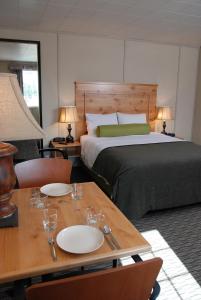 道森市Triple J Hotel的一间卧室配有床和一张桌子,上面有盘子