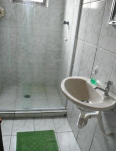 坎布里Alebelhinha Residencial Camburi Pousada的带淋浴和盥洗盆的浴室