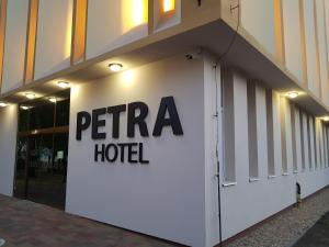尼赖吉哈佐Petra Hotel的白色的建筑,上面有五重酒店标志