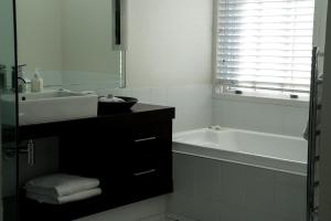 纳皮尔The Dome Boutique Apartments的白色的浴室设有水槽和浴缸。