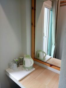 清莱班雅鲁酒店的一间带水槽和镜子的浴室以及窗户。