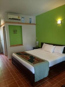 清莱班雅鲁酒店的一间卧室设有一张床和绿色的墙壁