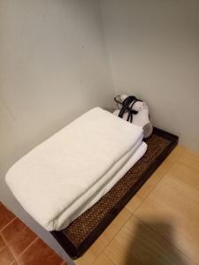清莱班雅鲁酒店的一间设有白色床单的房间