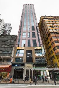 香港颐庭酒店的一座高大的建筑,前面的人在步行