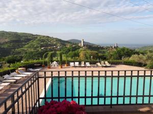 塞拉瓦莱皮斯托耶塞Agriturismo Villa Bracali的阳台享有游泳池的景致,配有椅子。
