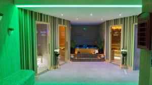 特雷比涅SL Industry Hotel的一间设有绿色窗帘的房间和一间带浴缸的房间