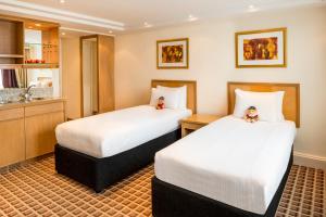 伦敦伦敦肯辛顿国敦塔拉酒店的酒店客房设有两张床和盥洗盆