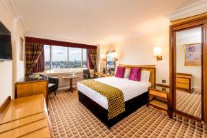 伦敦伦敦肯辛顿国敦塔拉酒店的酒店客房设有一张床和一个大窗户