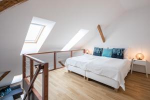 利贝雷茨Pytloun Apartments Liberec的卧室配有白色的床,铺有木地板