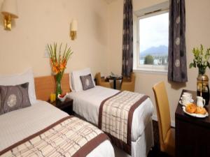 布罗德福德都诺丽酒店‘定制酒店’的酒店客房设有两张床和一张桌子。