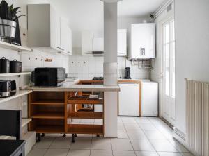波尔多Rolland的厨房配有白色橱柜和台面