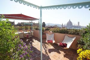 佛罗伦萨Antica Dimora Johlea的露台配有桌椅和遮阳伞