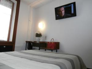 梅斯布里斯托尔梅斯中心火车站酒店的卧室配有一张床,墙上配有电视。