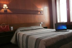 梅斯布里斯托尔梅斯中心火车站酒店的一间卧室配有一张带笔记本电脑的床