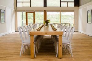帕尔Du Kloof Lodge的配有白色椅子的木桌