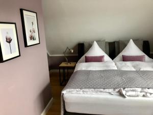 奥利希Boutique Hotel Lindenhof, Bed & Breakfast的卧室配有白色床和粉红色枕头