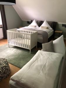 奥利希Boutique Hotel Lindenhof, Bed & Breakfast的一间卧室配有两张床和一张婴儿床。