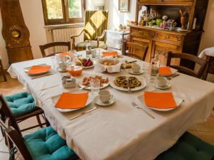 科斯蒂廖莱达斯蒂Bed and Breakfast Cascina Beccaris的一张桌子上放着食物和橙色餐巾