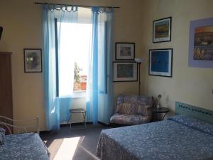 阿伦扎诺hotel albatros的卧室配有床、椅子和窗户。
