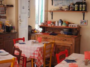 阿伦扎诺hotel albatros的厨房配有红色椅子和一张桌子及一张桌布
