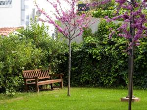 卡斯特尔德费尔斯SG科斯塔巴塞罗那公寓式酒店的紫色花树旁的公园长凳