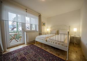 布莱德维拉马尔杰提卡公寓式酒店的一间卧室设有一张床和一个大窗户