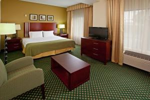 印第安纳波利斯Holiday Inn Express & Suites Indianapolis - East, an IHG Hotel的酒店客房带一张床、一台电视和一把椅子