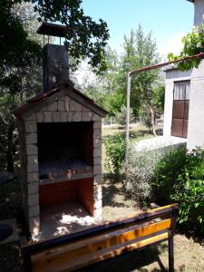 斯塔利格拉德-帕克利尼卡Country house Mia的院子里的砖炉,有长凳