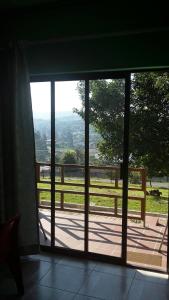 姆巴巴内Otentik guesthouse的通往享有田野美景的阳台的开放式门