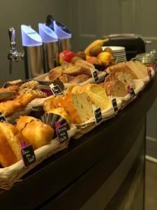 圣马洛Hotel Le Croiseur Ginette Intra Muros的一张桌子,上面摆放着各种面包和糕点