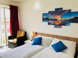 多马索风帆公寓式酒店的一间卧室配有一张带蓝色枕头的床