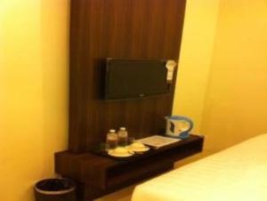 怡保丽景花园酒店的一间卧室配有一张床,墙上配有电视