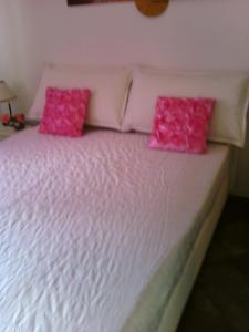 韦内雷港丽布塔公寓的一张白色的床,上面有粉红色枕头