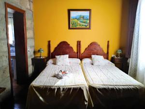 格拉纳迪利亚德亚沃纳贝拉维斯塔乡村度假屋的一间卧室设有两张床和黄色的墙壁